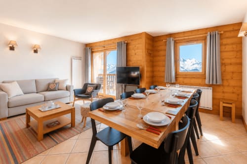 Spacieux appartement alpin à Arc 1800 avec table à manger, coin salon, intérieur en bois, vue sur les montagnes