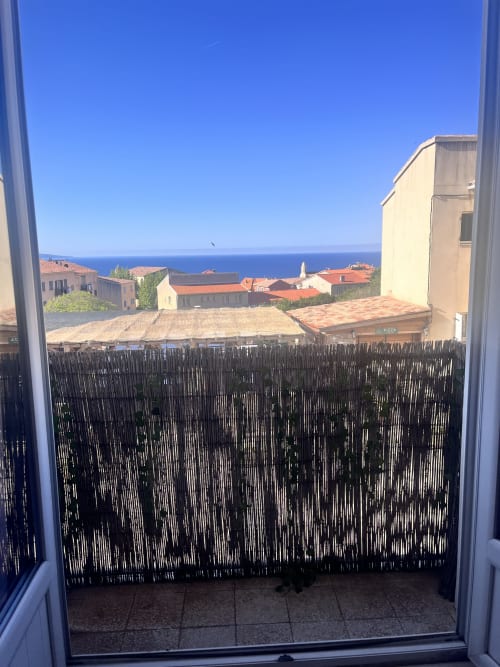 Vue depuis le balcon de la Casa Monica à Cargese : mer Méditerranée, village côtier et toits de tuiles rouges