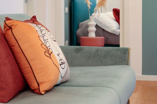 Cozy seating area in Pescara INN Family Connecting Suite with colorful pillows and sea-view artwork