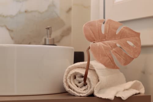 Bathroom décor at Pescara INN: rolled towel, potted plant, and ceramic dispenser on vanity