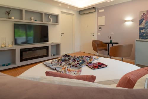Pescara INN Family Connecting Suite bedroom with bed, TV, fireplace, and comfortable seating area