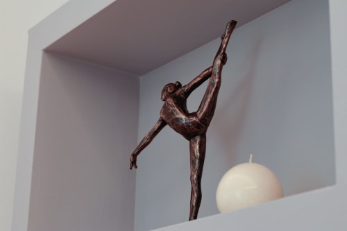 Bronze dancer sculpture and white candle in modern alcove at Pescara INN Family Suite
