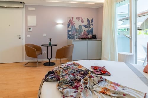 Pescara INN Family Suite with pink walls, wooden floors, modern furnishings and balcony access