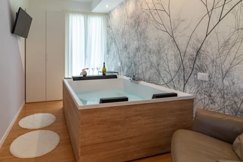 Luxurious spa bathtub in Essenza INN Family Suite at Pescara INN hotel with artistic branch wallpaper