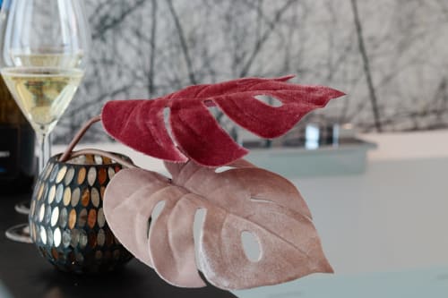 Elegant wine glass and decorative red-pink leaves with woven basket at Pescara INN's Essenza Family Suite
