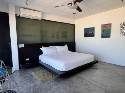 Modern king bed with white linens in Vidasoul BnB room, La Vinorama, MX, featuring ceiling fan and colorful wall art
