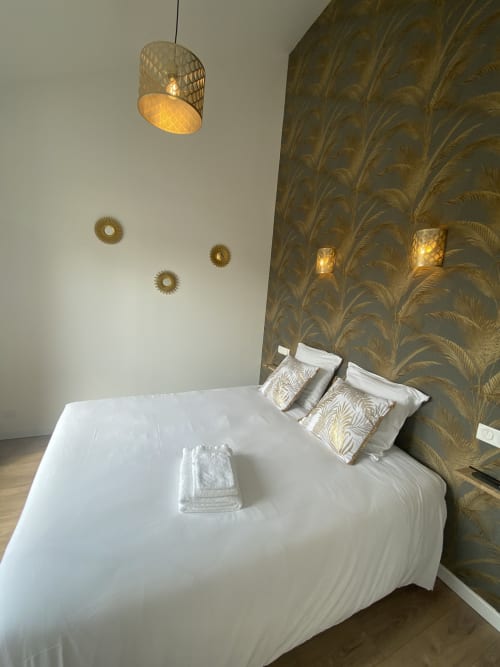 Modernes Schlafzimmer im La Maison Blanche mit weißem Bett, gemustertem Kopfteil, Pendelleuchte und dekorativen Wandleuchten