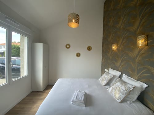 Modernes Schlafzimmer in La Maison Blanche in Bouguenais mit weißem Bett, goldenem Bettkopfteil, Pendelleuchte und Gartenblick