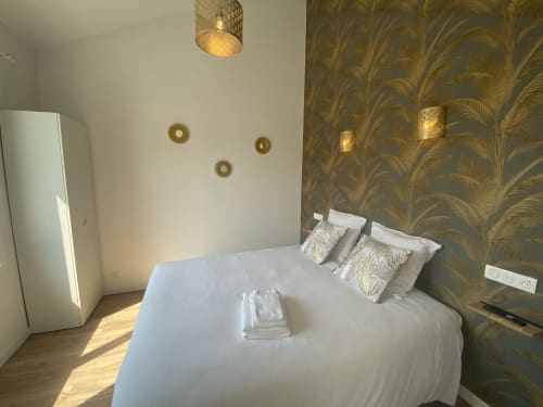 Modernes Schlafzimmer im La Maison Blanche mit weißem Bett, Goldblatt-Tapete und Gartenblick in Bouguenais