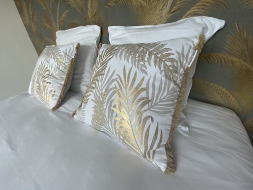 Dekorative weiß-goldene Kissen mit Palmenmotiv und Fransen auf dem Bett im La Maison Blanche, Bouguenais