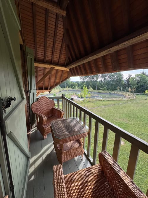 Balcon couvert avec mobilier en rotin dominant les terres agricoles à LA ROQUERIE, Bonneville-la-Louvet