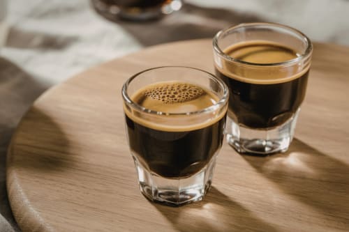 Due espresso con crema su tavolo in legno presso il Corte Baruzzo Relais a Volta Mantovana
