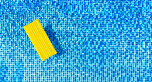 Zattera gonfiabile gialla che galleggia in una piscina azzurra presso il Corte Baruzzo Relais a Volta Mantovana, Italia