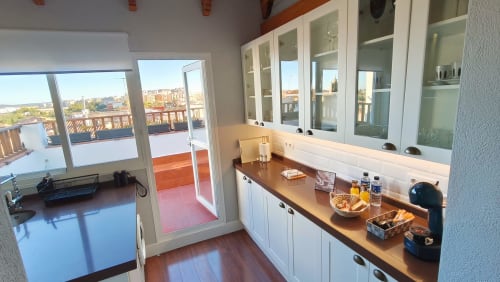 Cocina moderna con encimeras de madera, muebles blancos y vistas a la terraza en Mirador Medieval, Cáceres