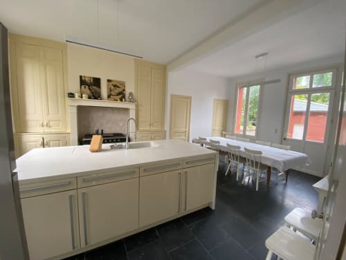 Cuisine moderne avec placards crème, plan de travail blanc et coin repas au Gîte Presbytère à Cayeux-sur-Mer