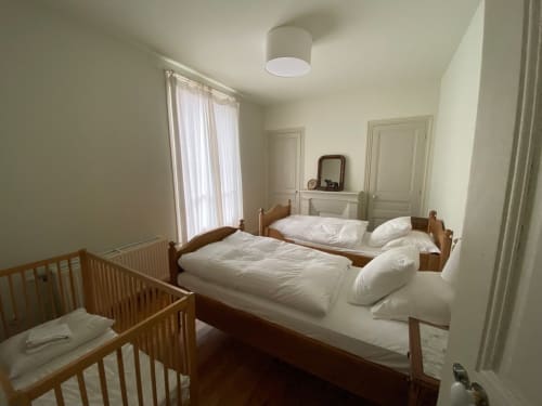 Chambre lumineuse au Gîte Presbytère du Hidden Bay Hotel à Cayeux-sur-Mer avec lit en bois, lit bébé et linge blanc