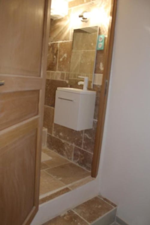 Salle de bain moderne de la Chambre Coco à la Maison d'hôtes Madiana 89, avec vasque blanche, douche carrelée à paroi vitrée et pierre