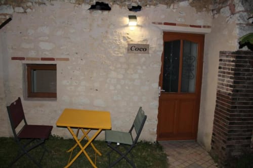 Terrasse du jardin Coco Room du B&B Madiana 89 à Bellechaume, France, avec table et chaises jaunes