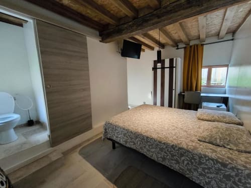 Chambre Coco à la Maison d'hôtes Madiana 89 à Bellechaume avec lit, poutres en bois, TV et vue sur le jardin
