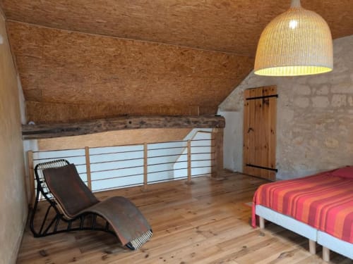 Chambre loft moderne à Madiana 89 à Bellechaume avec parquet, suspension en rotin et vue sur jardin