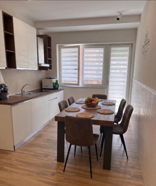 Cucina e zona pranzo moderna di Anima Est BnB a Napoli con tavolo in legno, sedie contemporanee e finestre luminose
