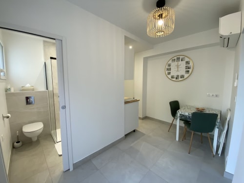 Modern apartment kitchen and dining area at La Maison Blanche in Bouguenais with white decor