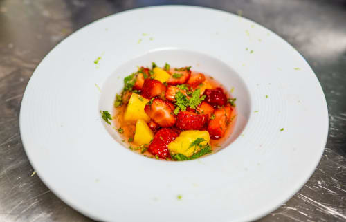 Salade de fruits colorée aux fraises et mangue dans une assiette blanche à l'hôtel Lieu-dit Boulage à Marquefave