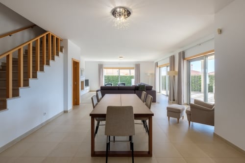 Área aberta de jantar e sala de estar na Marvellous Villa em Be SilverCoast, Serra D'El Rei, com escada de madeira e design moderno
