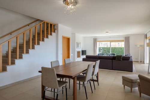 Sala de jantar moderna com escada de madeira, mesa de refeições e área de estar em Be SilverCoast, Serra D'El Rei