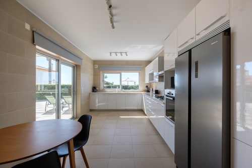 Cozinha moderna e sala de jantar da Villa Marvellous em Be SilverCoast, Serra D'El Rei, com vista para a piscina e terraço exterior
