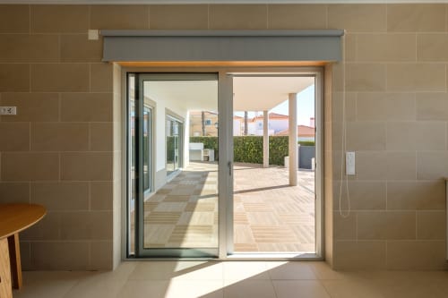 Interior de villa moderna com portas de vidro deslizantes que abrem para o terraço e área de piscina em Be SilverCoast, Serra D'El Rei
