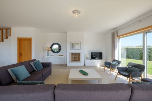 Sala de estar moderna na villa Be SilverCoast em Serra D'El Rei com móveis contemporâneos e vistas para o jardim
