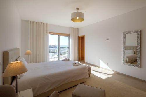 Quarto moderno e iluminado na Marvellous Villa em Be SilverCoast com vista para a piscina, móveis em tons creme e vista para o mar do terraço