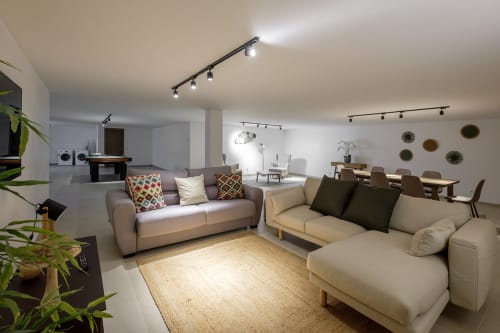 Sala de estar moderna da villa Be SilverCoast com sofás creme, tapete natural e iluminação de trilho em Serra D'El Rei