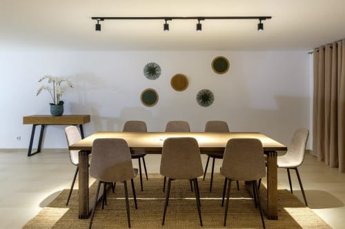 Sala de jantar moderna na villa Be SilverCoast com mesa de madeira, cadeiras estofadas, pratos decorativos e luz natural