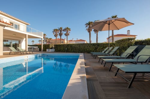 Villa SilverCoast Marvellous em Serra D'El Rei, Portugal - piscina com espreguiçadeiras, guarda-sol e palmeiras