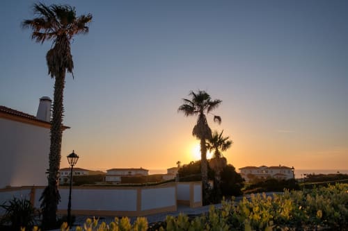 Vista do pôr do sol na villa Be SilverCoast em Serra D'El Rei com palmeiras e área de piscina