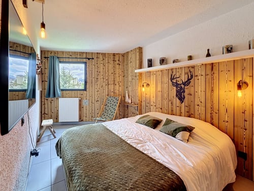 Chambre chaleureuse aux boiseries à Les Tanières de Montgenèvre, lit double, décor alpin et vue montagne