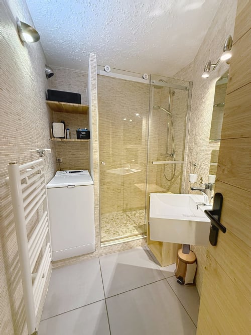 Salle de bain moderne avec douche à l'italienne, lavabo blanc, machine à laver et radiateur sèche-serviettes à Les Tanières
