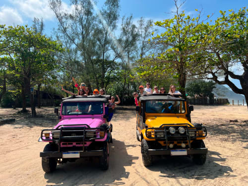 Jipes coloridos com turistas em aventura de praia no Rio Vibes Hostel, Rio de Janeiro