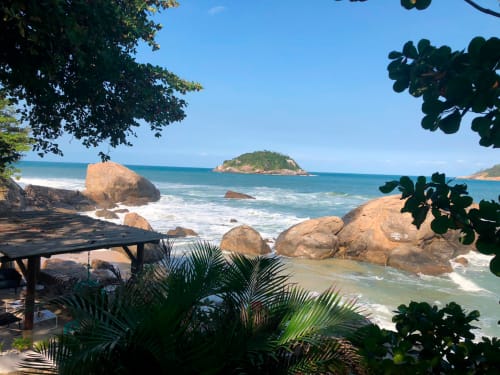 Praia tropical com blocos de granito, águas turquesas e vista para a ilha na pousada Rio Vibes, Rio de Janeiro