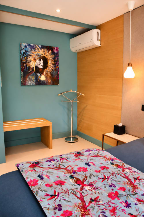 Chambre moderne à Au Pied Des Oliviers avec murs turquoise, banquette orange, literie fleurie et décor artistique à Calenzana