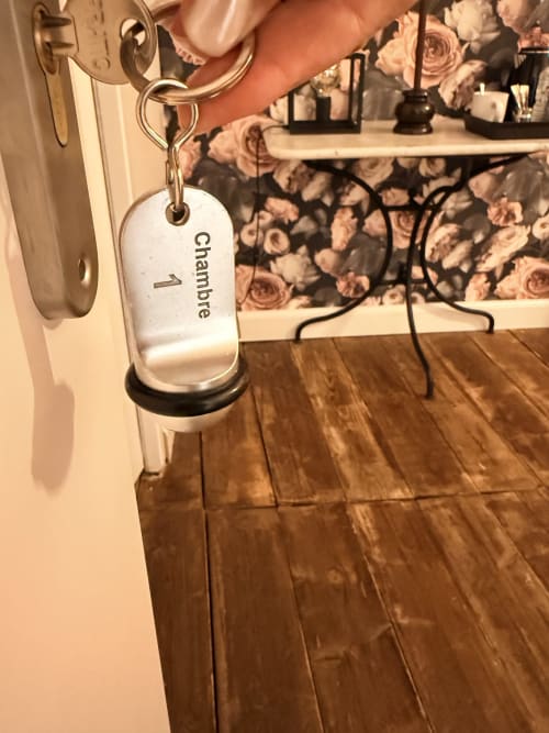 Étiquette de clé de chambre « Chambre 1 » suspendue à la poignée de porte au gîte Le Montreal à Montréal du Gers