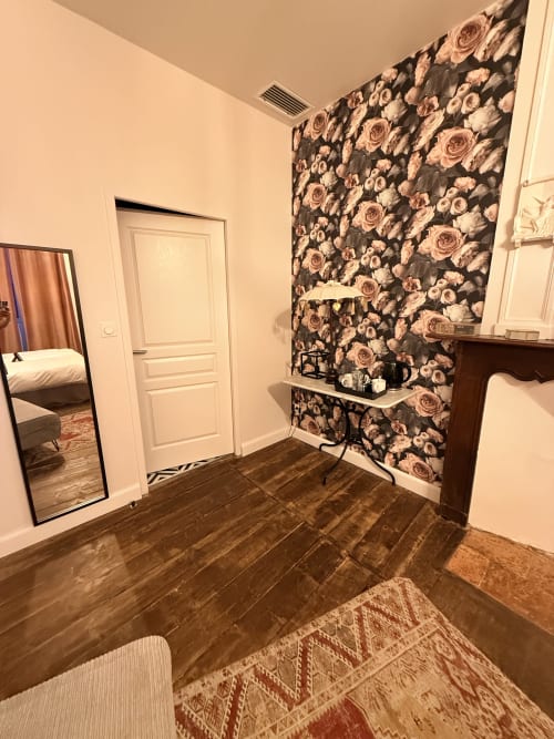 Entrée de la chambre Montreal avec papier peint à motifs floraux, parquet et miroir à Montréal du Gers, France