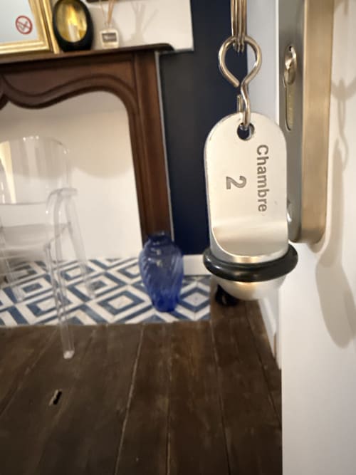 Porte-clés d'hôtel étiqueté « Chambre 2 » suspendu à une chaîne au gîte Le Montreal à Montréal du Gers