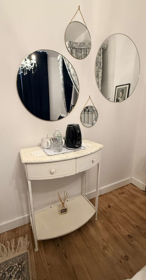 Vanité élégante avec mobilier blanc, miroirs décoratifs suspendus et équipements hôteliers au Le Montreal B&B