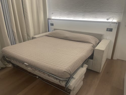 Modern bedroom at Like at Home Palau with queen bed, white headboard, neutral bedding, garden view window, and contemporary