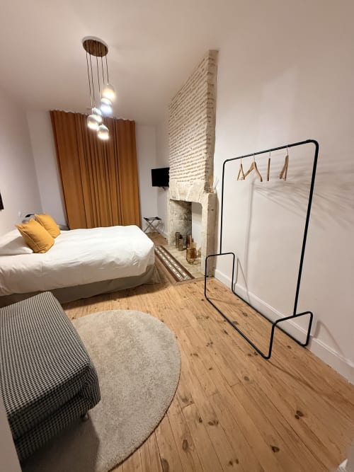 Chambre moderne à Le Montreal B&B à Montréal du Gers avec lit, luminaires suspendus, cheminée et portant