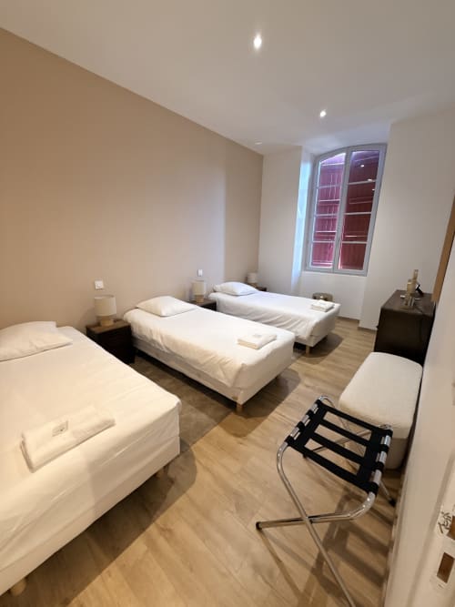 Chambre triple du Montreal BnB avec trois lits simples, parquet et vue sur la ville à Montréal du Gers