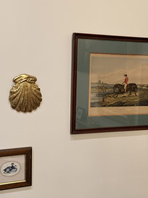 Mur de galerie au Le Montreal B&B Montréal du Gers avec gravure équestre vintage, coquillage en laiton et tableau de canard encadré